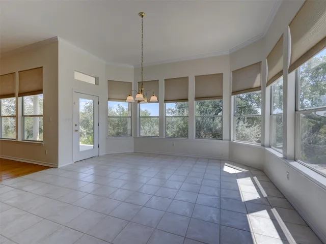 a view of an empty room with glass door and windows