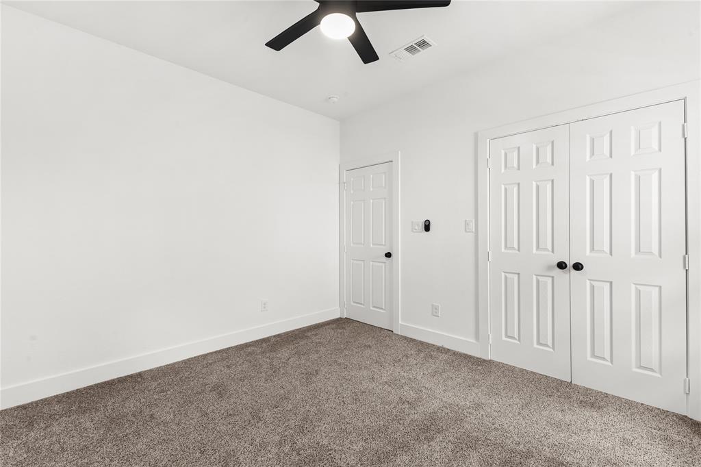 101 Ross Street Sulphur Springs, TX 75482 - Photo 22 of 30 Unfurnished bedroom featuring a closet, dark carpet, and ceiling fan