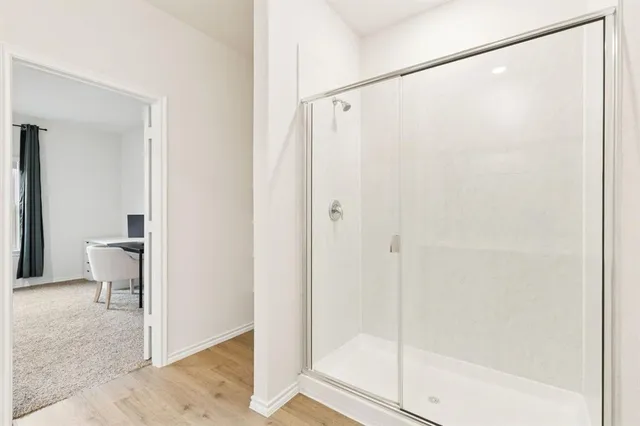 a bathroom with a shower and a glass door