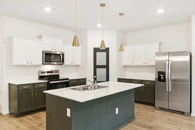 a kitchen with a sink and stainless steel appliances