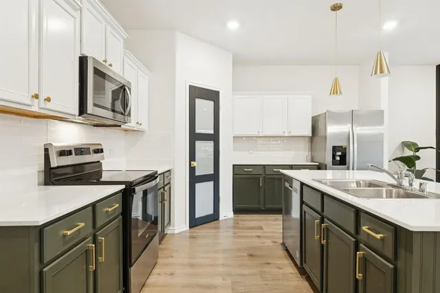 a kitchen with stainless steel appliances granite countertop a sink stove and refrigerator