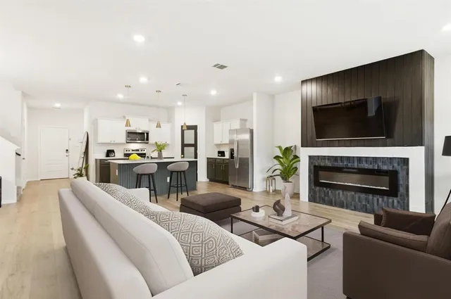 a living room with furniture a fireplace and a flat screen tv