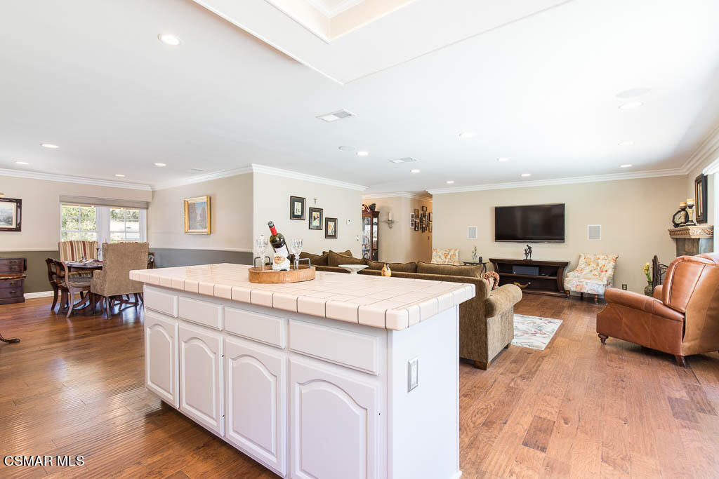 1161 Rambling Road Simi Valley, CA 93065 - Photo 8 of 48 a large living room with stainless steel appliances kitchen island granite countertop a large couch and a dining table with wooden floor