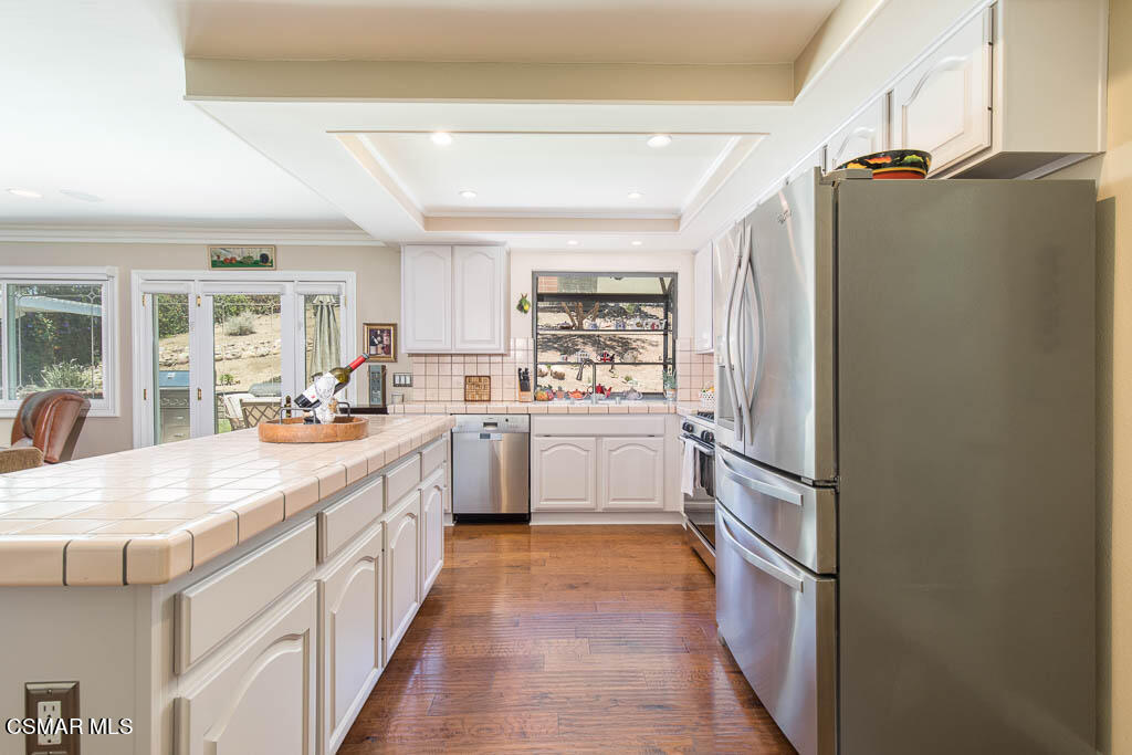 1161 Rambling Road Simi Valley, CA 93065 - Photo 9 of 48 a large kitchen with a refrigerator a sink a stove and cabinets