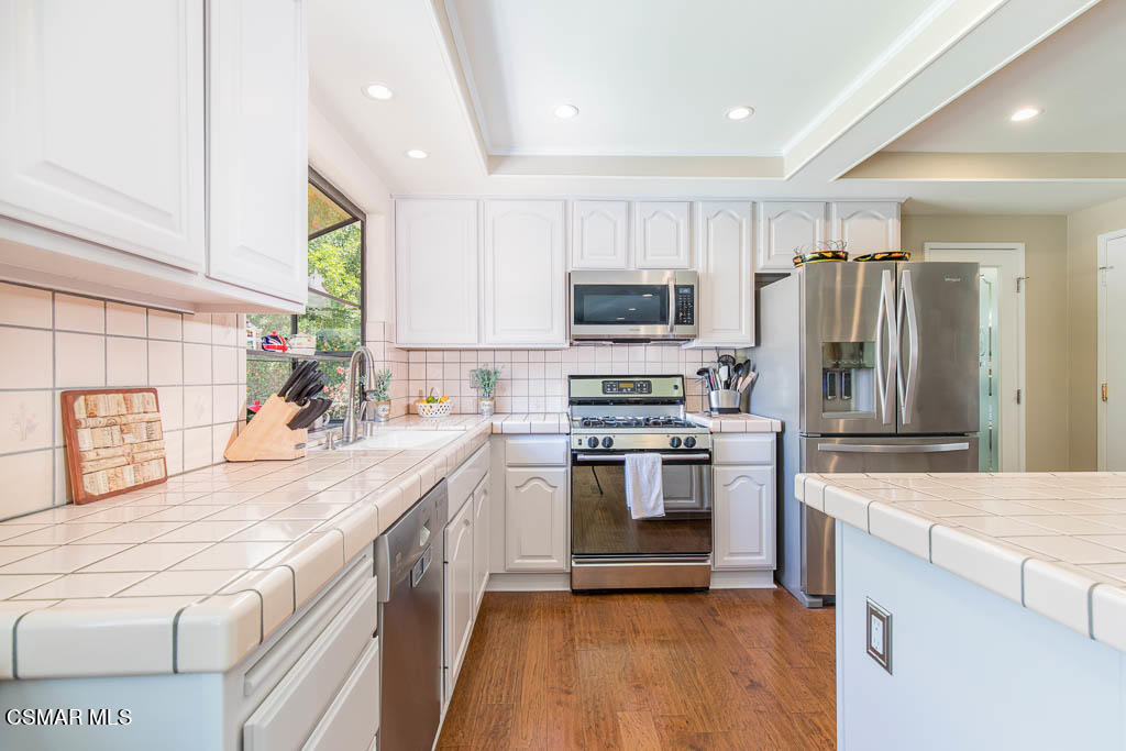 1161 Rambling Road Simi Valley, CA 93065 - Photo 10 of 48 a kitchen with kitchen island granite countertop a sink appliances cabinets and a counter top space