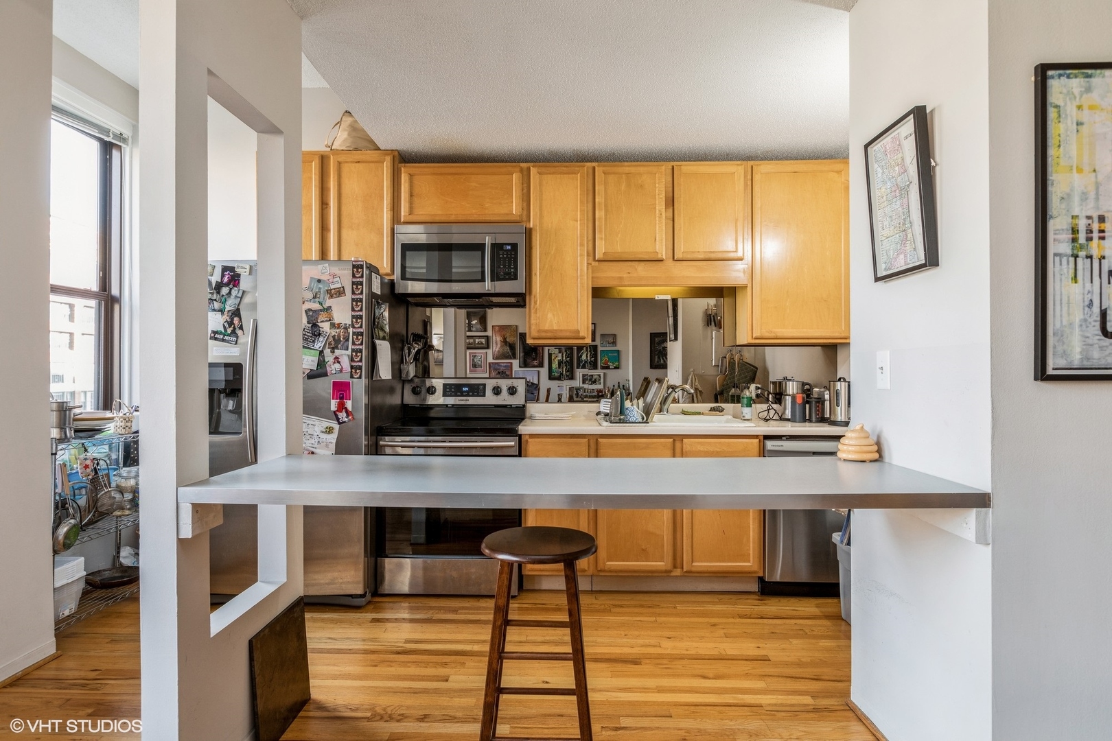 600 South Dearborn Street, Unit 1104 Chicago, IL 60605 - Photo 3 of 10 a view of a kitchen with kitchen island granite countertop a window and a view of living room