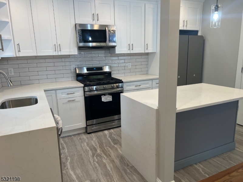 33 Morris Avenue Summit, NJ 07901 - Photo 5 of 28 a kitchen with stainless steel appliances a stove a sink and a refrigerator