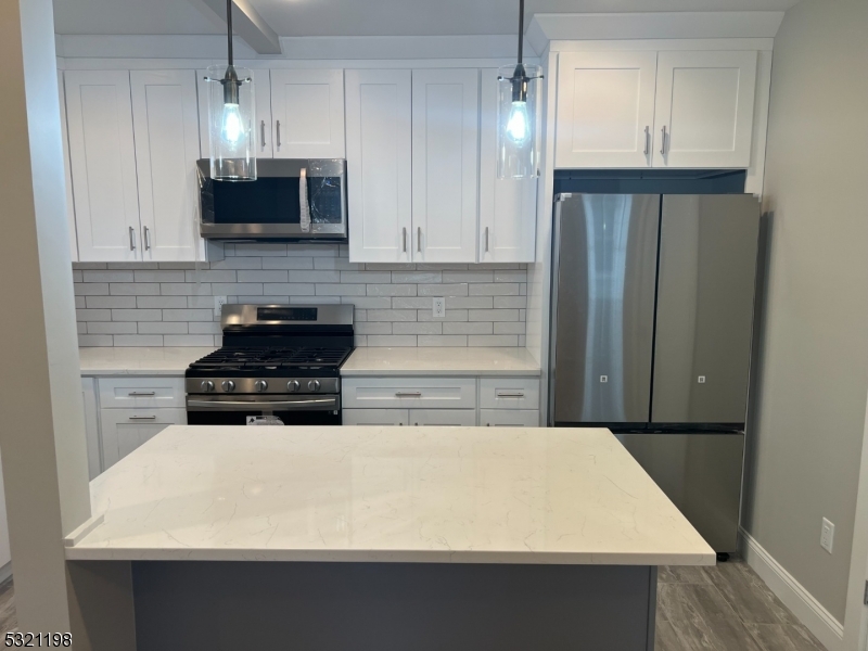 33 Morris Avenue Summit, NJ 07901 - Photo 6 of 28 a kitchen with stainless steel appliances a sink a stove a microwave and cabinets