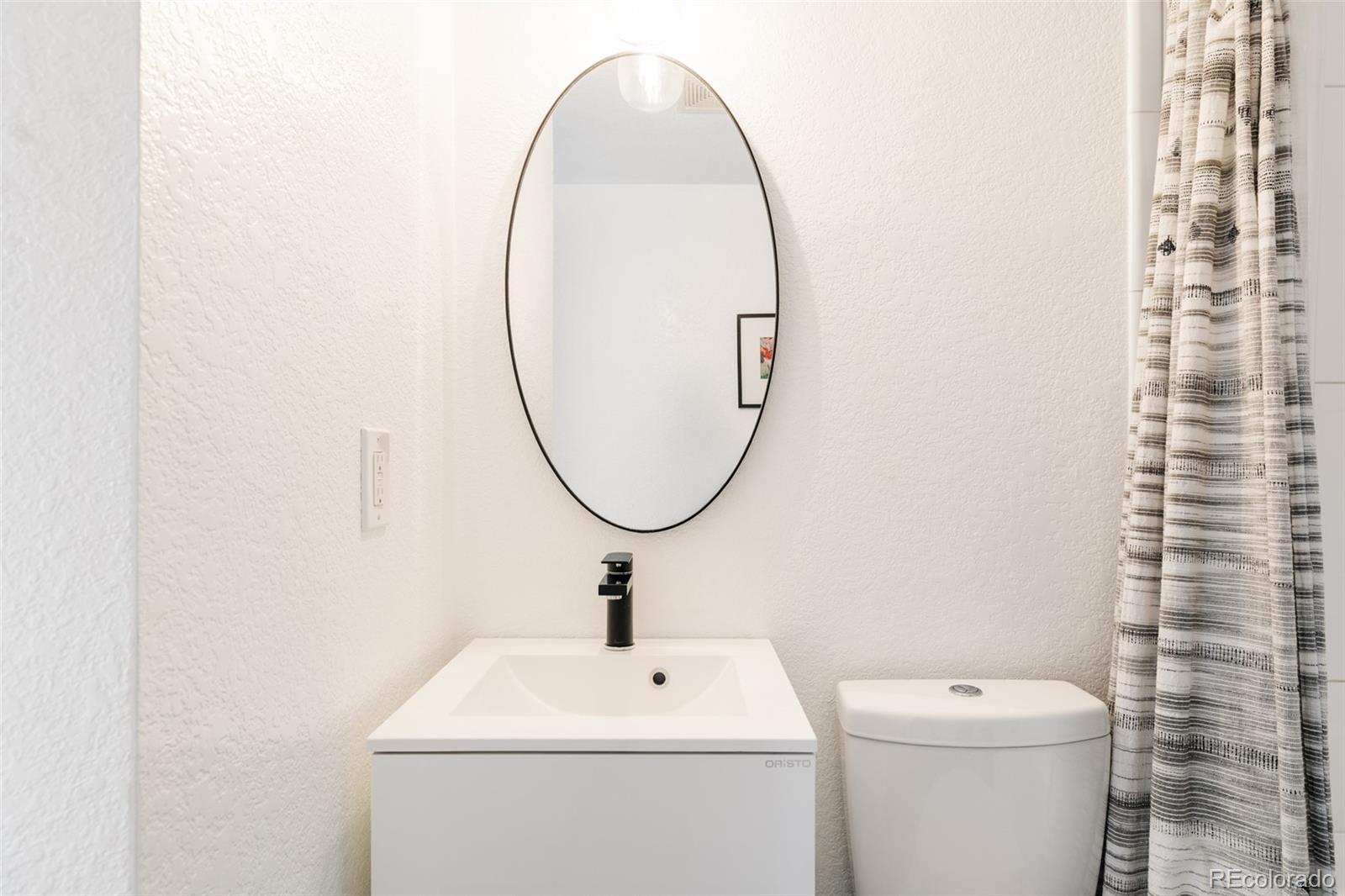 3100 North High Street Denver, CO 80205 - Photo 16 of 28 a bathroom with a toilet a sink and a mirror