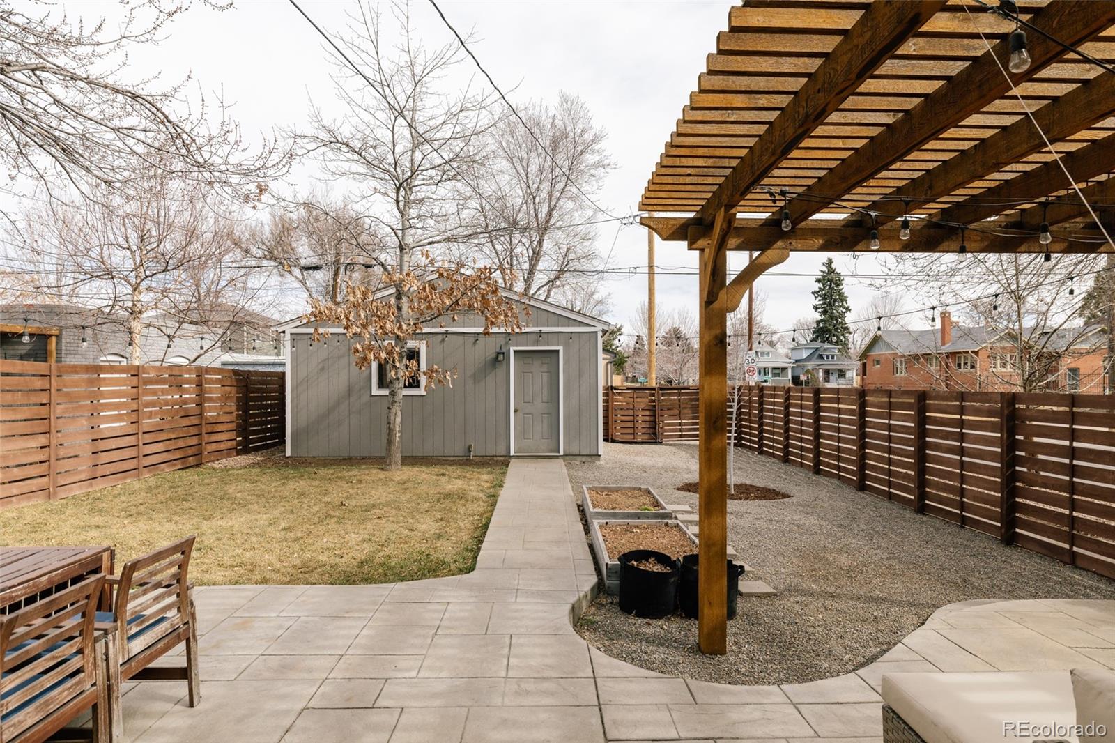 3100 North High Street Denver, CO 80205 - Photo 19 of 28 a view of a patio with table and chairs with wooden fence and plants