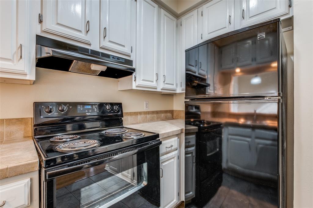 4034 Rawlins Street, Unit 102 Dallas, TX 75219 - Photo 13 of 24 a kitchen with stainless steel appliances granite countertop a stove and a microwave
