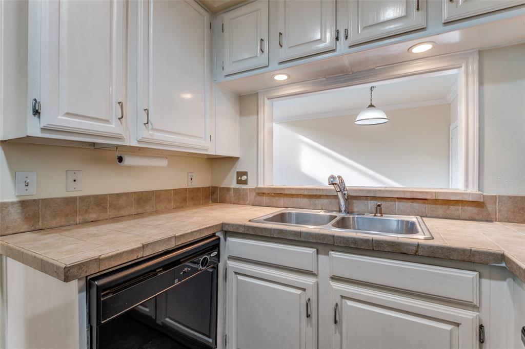 4034 Rawlins Street, Unit 102 Dallas, TX 75219 - Photo 14 of 24 a kitchen with granite countertop cabinets stainless steel appliances and a sink