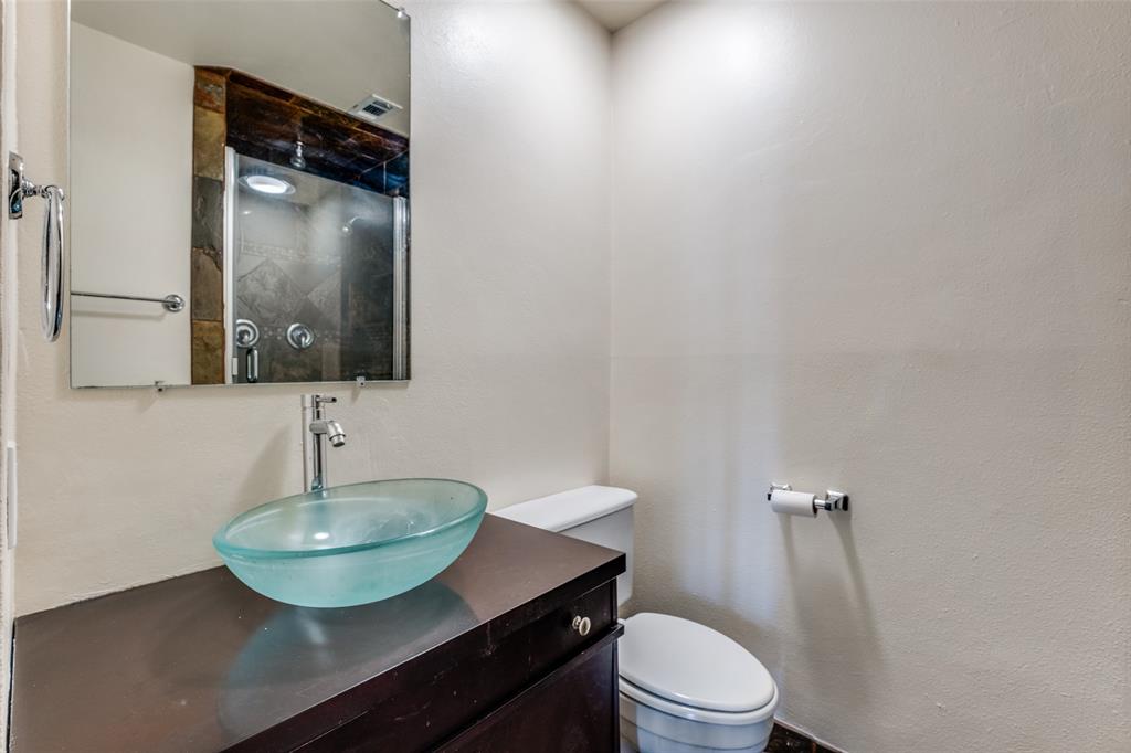 4034 Rawlins Street, Unit 102 Dallas, TX 75219 - Photo 15 of 24 a bathroom with a toilet sink and mirror