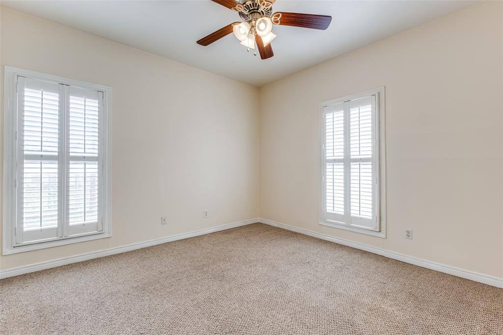 4034 Rawlins Street, Unit 102 Dallas, TX 75219 - Photo 18 of 24 an empty room with chandelier fan and windows