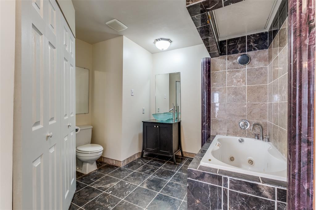 4034 Rawlins Street, Unit 102 Dallas, TX 75219 - Photo 21 of 24 a bathroom with a bathtub shower sink and toilet