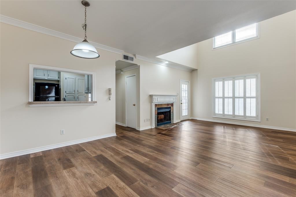 4034 Rawlins Street, Unit 102 Dallas, TX 75219 - Photo 5 of 24 a view of empty room with wooden floor and fireplace