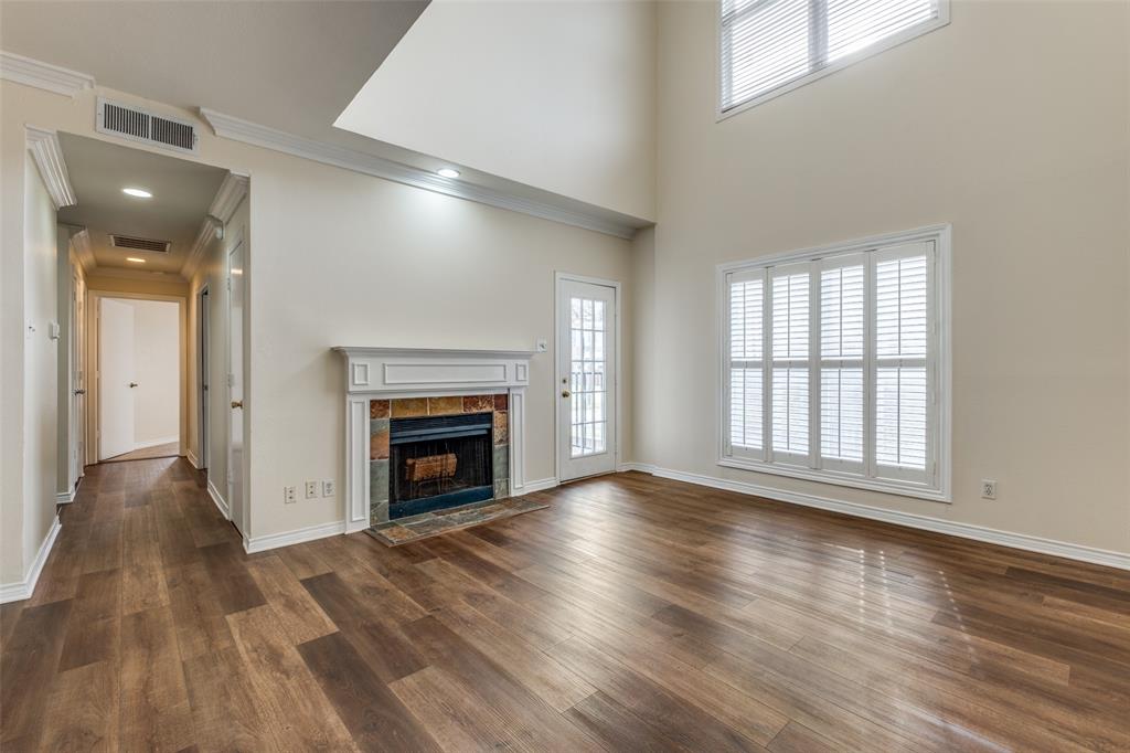 4034 Rawlins Street, Unit 102 Dallas, TX 75219 - Photo 7 of 24 an empty room with wooden floor fireplace and windows