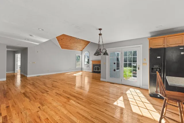 a view of a livingroom with a dinning area hardwood floor and a ceiling fan