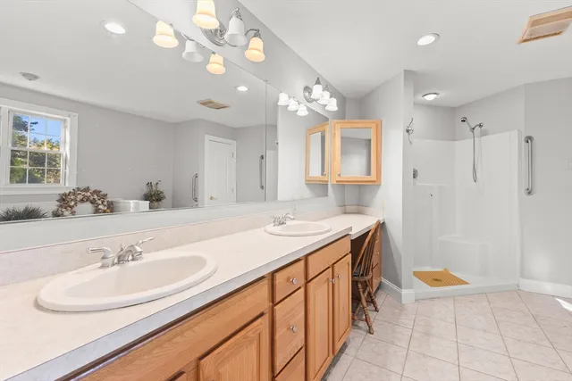 a bathroom with a sink a vanity a mirror and a shower