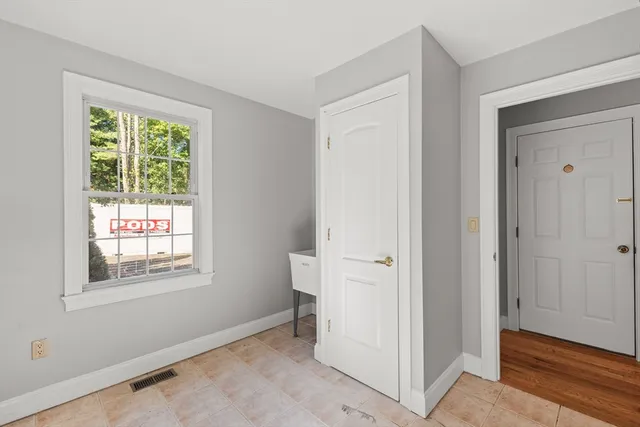 a view of an empty room with window and closet area