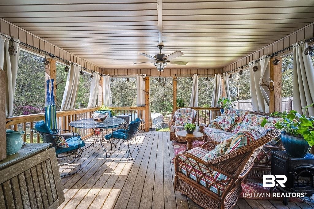 7420 Pake Road Saraland, AL 36571 - Photo 19 of 35 Sunroom with an outdoor living space, a wood stove, and a ceiling fan