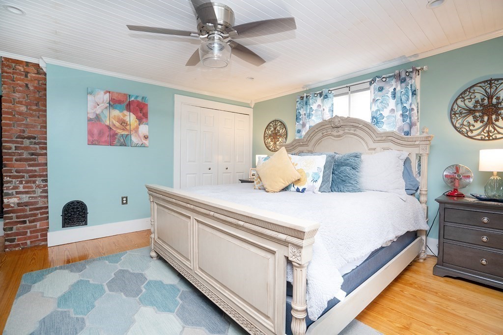 215 Market Street Amesbury, MA 01913 - Photo 23 of 41 a spacious bedroom with a bed and a chandelier