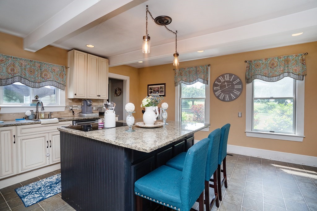 215 Market Street Amesbury, MA 01913 - Photo 9 of 41 a kitchen with granite countertop white cabinets a dining table and chairs