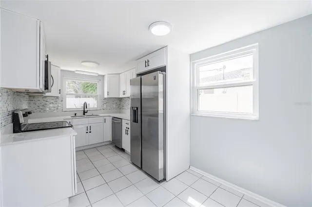 a kitchen with a refrigerator sink and cabinets