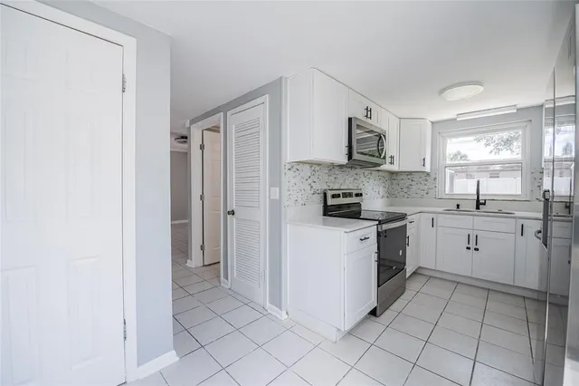 a kitchen with a refrigerator sink and cabinets