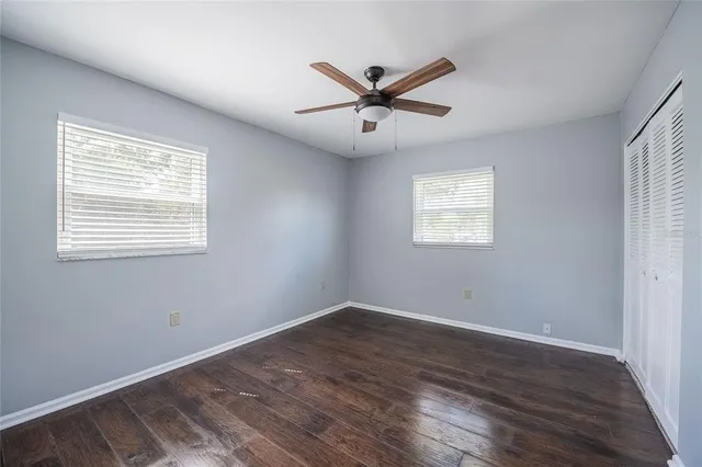 a view of a big room with wooden floor and windows