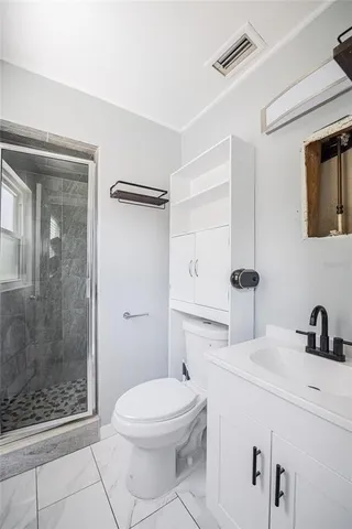 a bathroom with a toilet a sink and shower