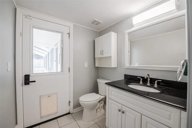 a bathroom with a granite countertop sink a toilet and a mirror