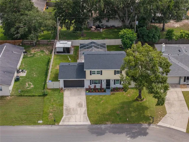 an aerial view of a house with a garden and lake view