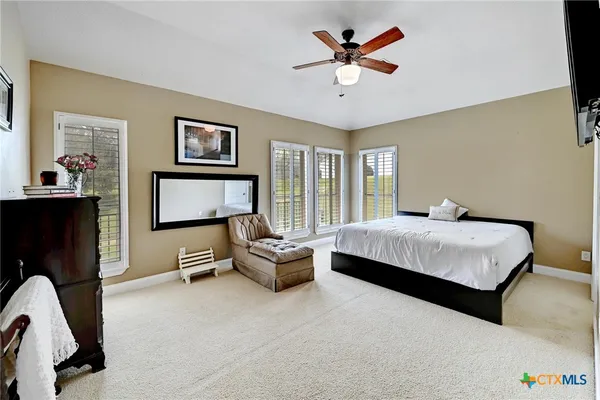 a spacious bedroom with a bed a couch and a chandelier