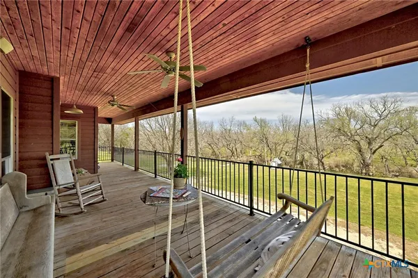 a balcony with wooden floor table and chairs