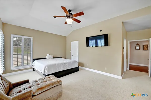 a bedroom with a bed a couch and a window