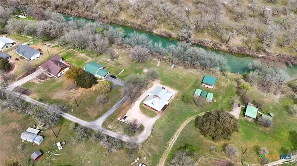 a aerial view of a house with swimming pool and next to a yard
