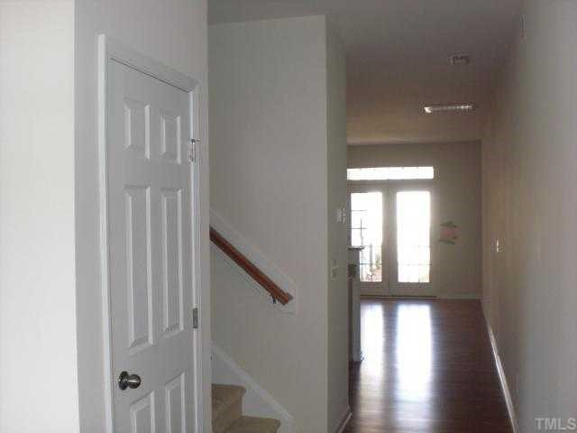 1342 Regulator Street Raleigh, NC 27603 - Photo 2 of 4 a view of a hallway with wooden floor and stairs