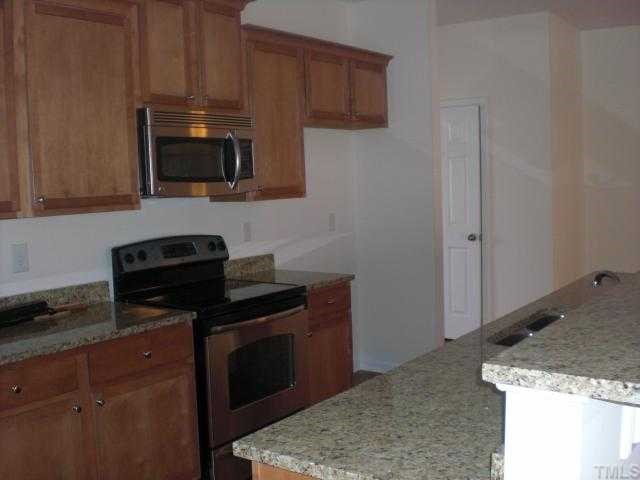 1342 Regulator Street Raleigh, NC 27603 - Photo 4 of 4 a kitchen with stainless steel appliances granite countertop a stove a microwave and sink