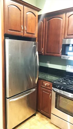 a kitchen with granite countertop a refrigerator and a sink