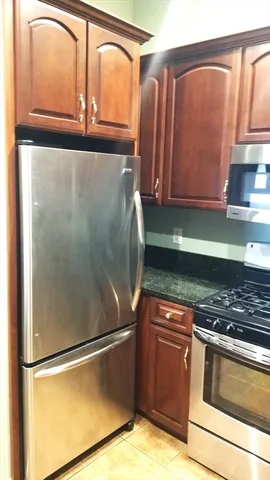 a kitchen with granite countertop a refrigerator and a sink
