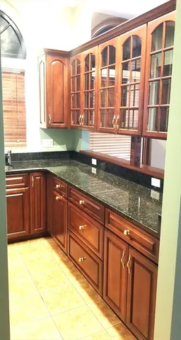 a kitchen with granite countertop wooden cabinets a sink and dishwasher