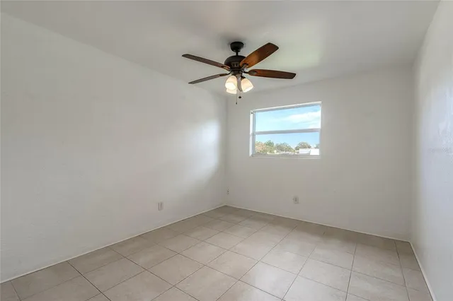 an empty room with a window and a fan