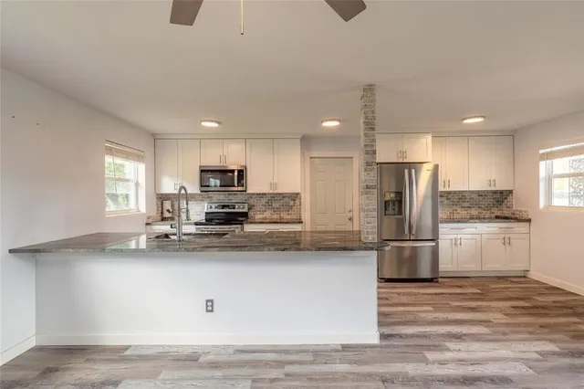 a kitchen with stainless steel appliances a refrigerator sink and microwave