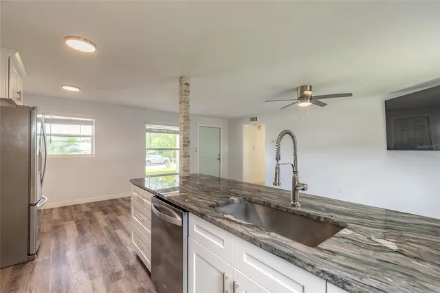 a view of a white house with a yard and plants