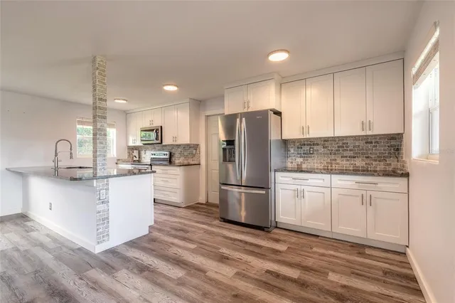 a kitchen with white cabinets and stainless steel appliances