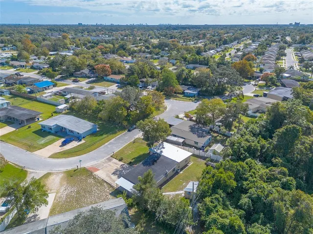 an aerial view of residential houses with outdoor space and lake view