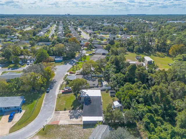 an aerial view of residential houses with outdoor space and trees