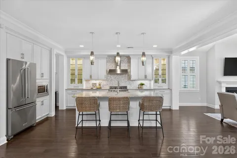 a large kitchen with cabinets table and chairs