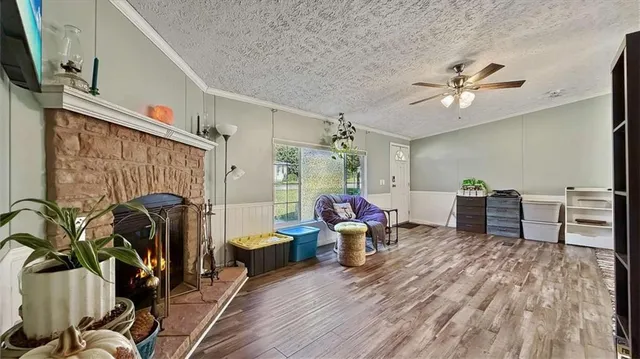 a kitchen with stainless steel appliances granite countertop a refrigerator a stove and a sink with wooden floors